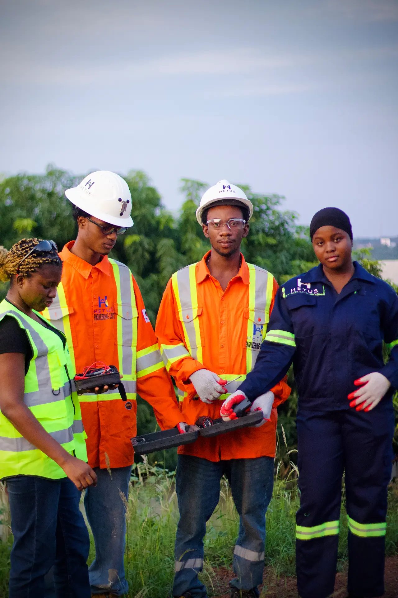 Young HEL engineers in safety gear learning with field tools